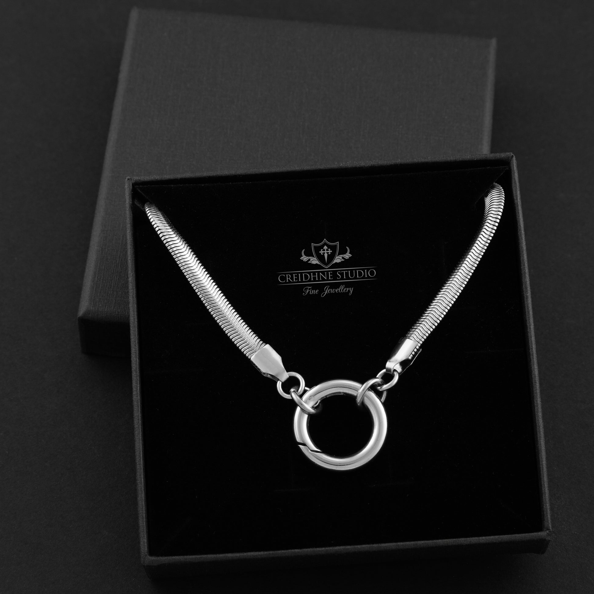Silver necklace with a circular pendant in a black box, branded 'Creshte Studio'.