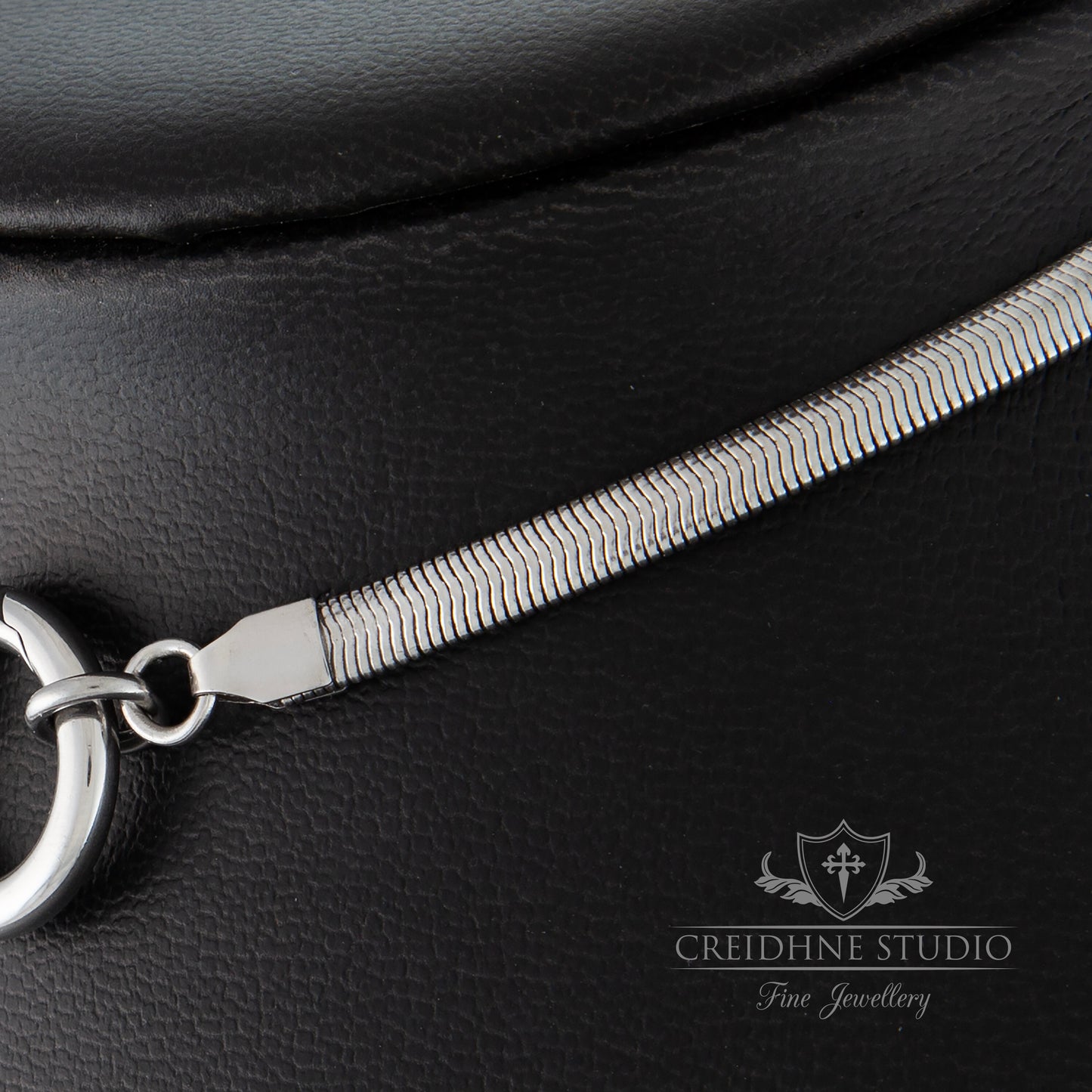 Close up of silver snake chain collar on black background 