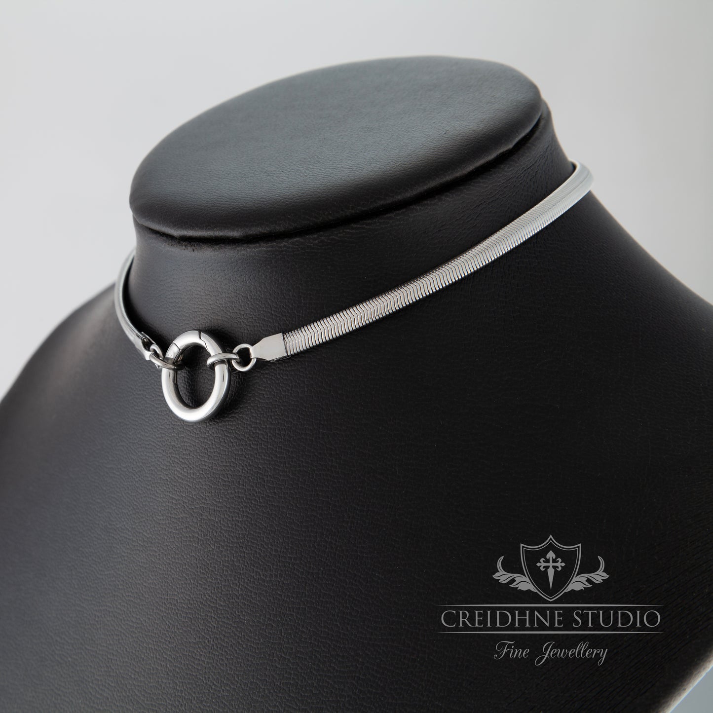 Side view of silver snake chain collar black leather mannequin, Creidhne Studio logo