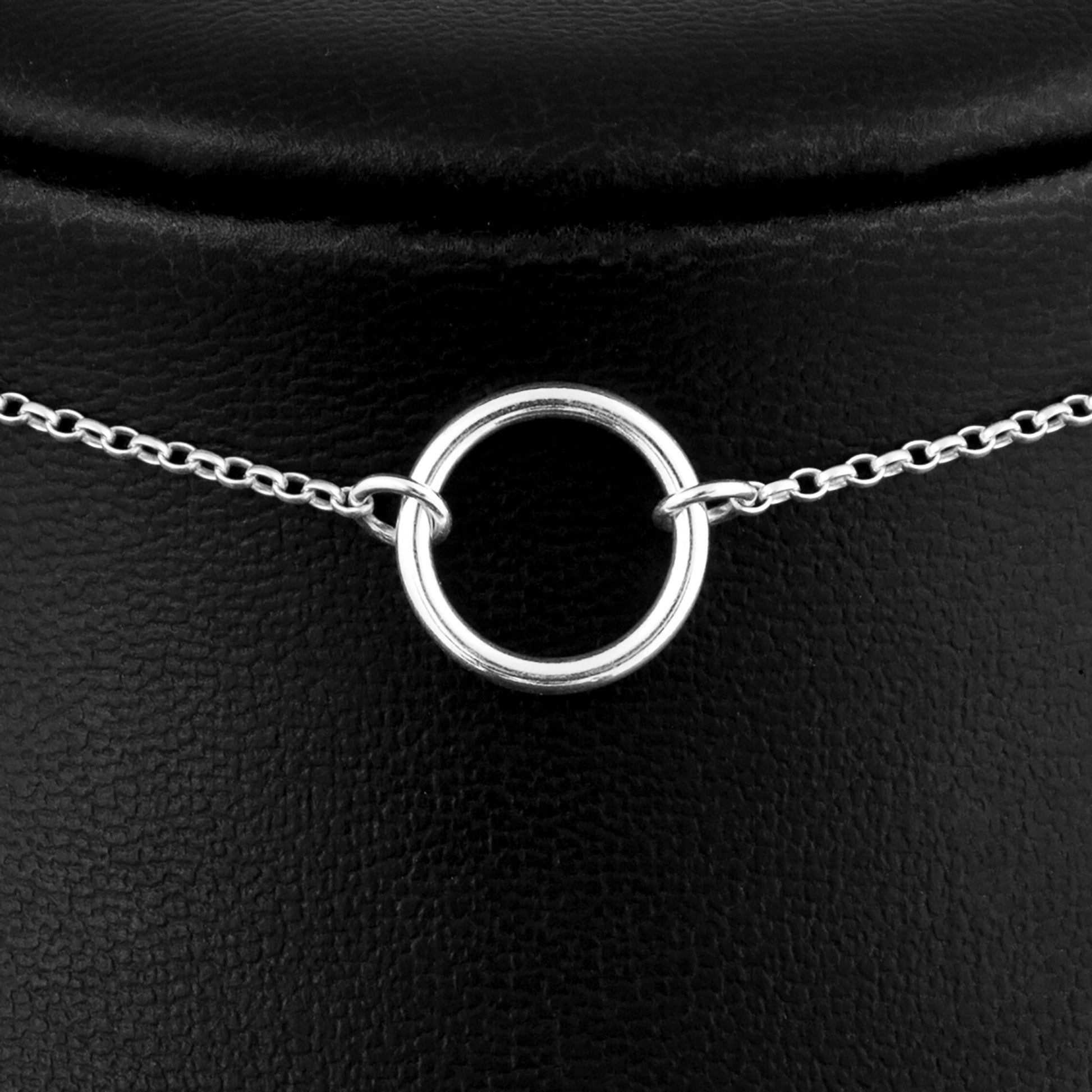 Close up of permanently locking silver day collar consisting of a delicate silver chain with a small 15mm diameter O ring suspended in the centre. The O ring is made of 1.8mm thick silver wire.