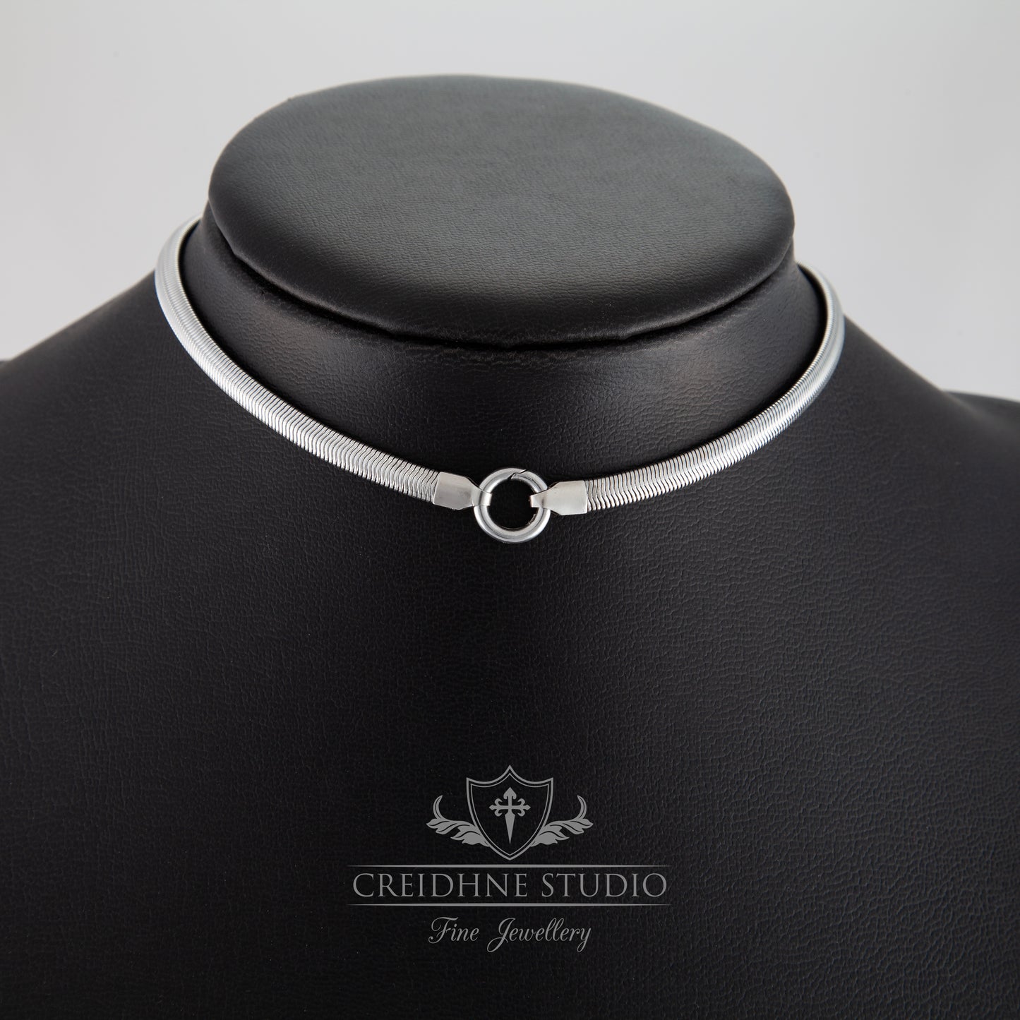 Silver flat snake collar on a black mannequin with 'Creidhne Studio' branding.
