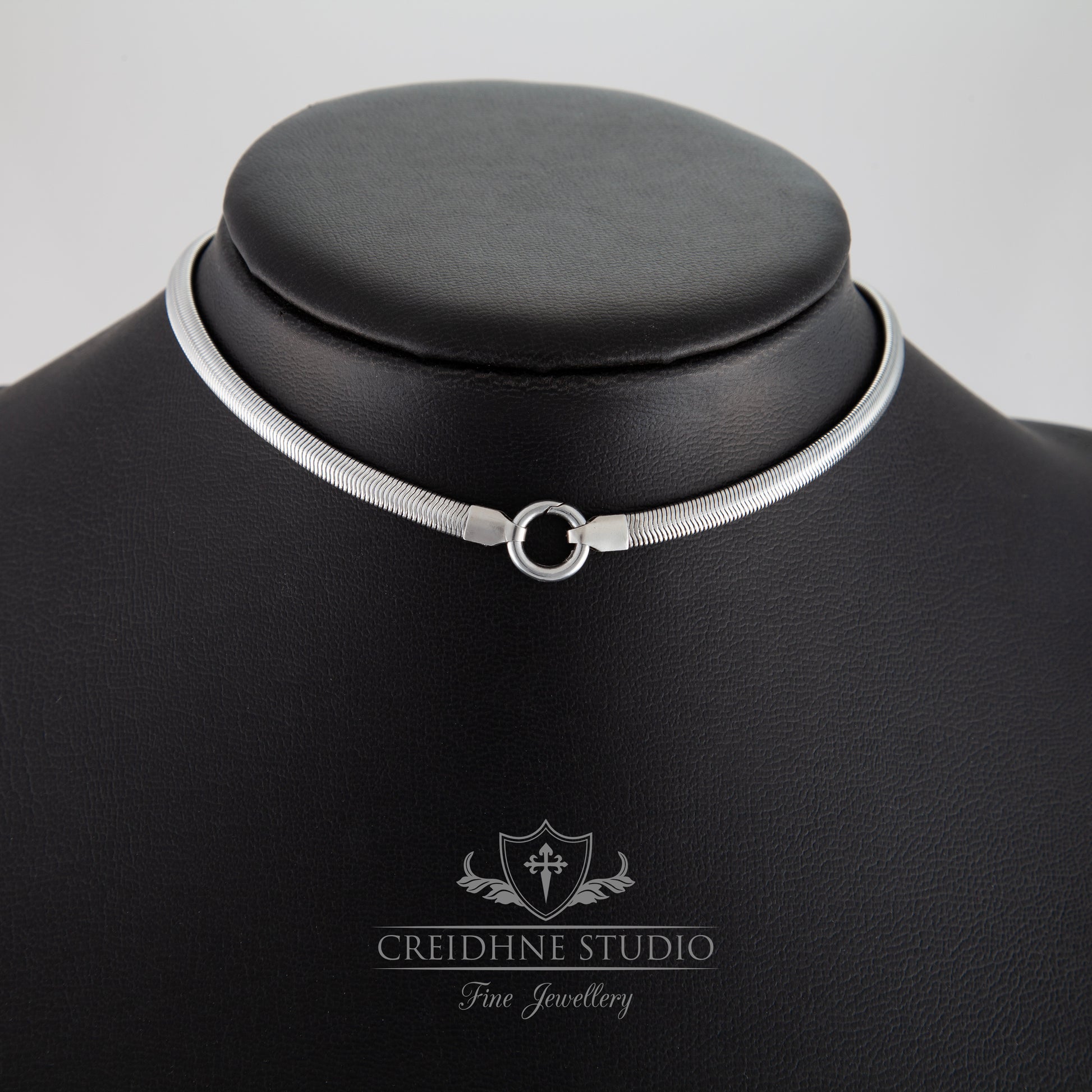 Silver flat snake collar on a black mannequin with 'Creidhne Studio' branding.